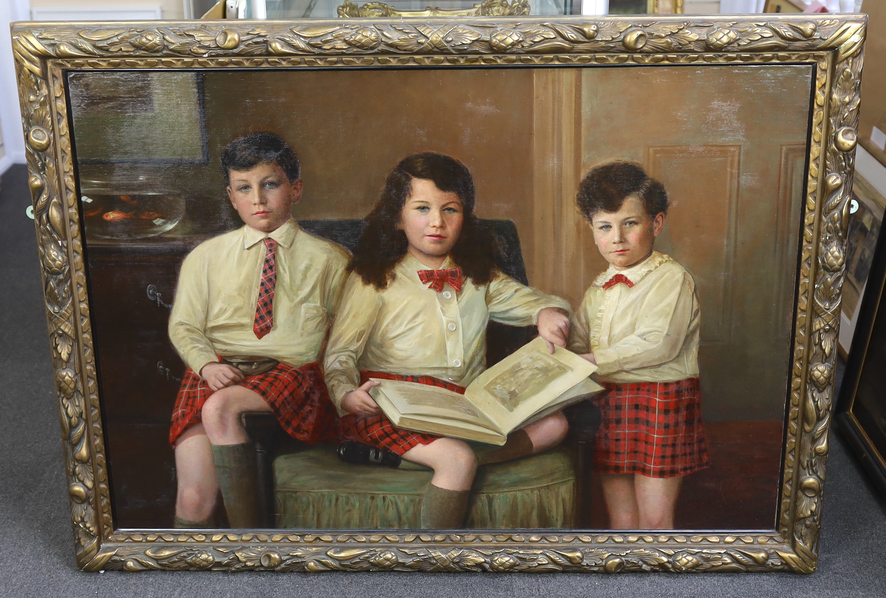 J.W. Beaufort (fl. circa 1920-30), Portrait of three Scottish children in a drawing room, all wearing Cameron tartan kilts, oil on canvas, 87 x 125cm